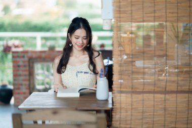 Kız bahçede kitap okuyor.