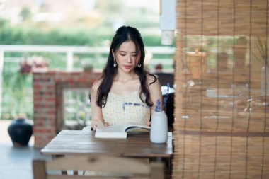 Kız bahçede kitap okuyor.