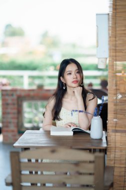 Kız bahçede kitap okuyor.