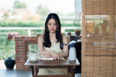 Kız bahçede kitap okuyor.