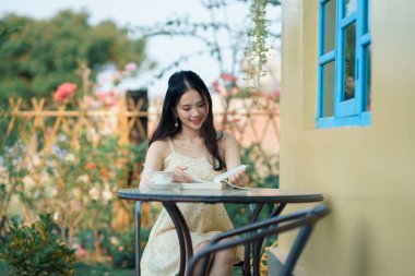 Kız bahçede kitap okuyor.