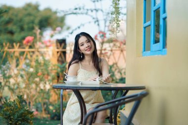 Kız bahçede kitap okuyor.