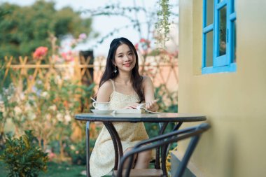 Kız bahçede kitap okuyor.