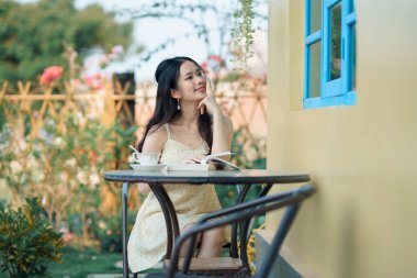 Kız bahçede kitap okuyor.