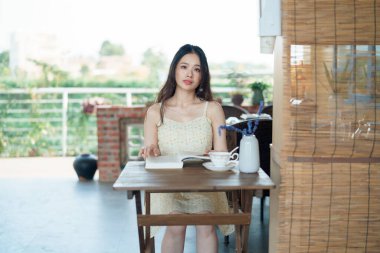 Kız bahçede kitap okuyor.