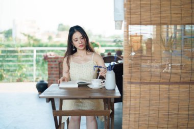 Kız bahçede kitap okuyor.