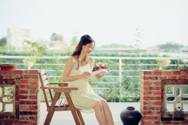 Kız bahçede kitap okuyor.