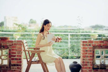 Kız bahçede kitap okuyor.