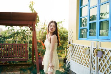 Kız bahçede kitap okuyor.