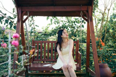 Kız bahçede kitap okuyor.