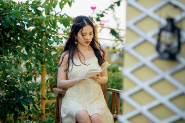 Kız bahçede kitap okuyor.