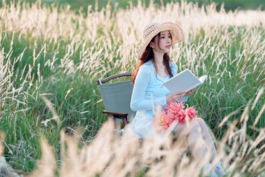 Genç kızlar bahçede kitap okurlar.