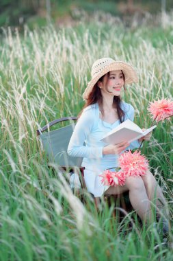 Genç kızlar bahçede kitap okurlar.