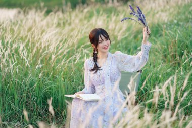 Genç kızlar bahçede kitap okurlar.