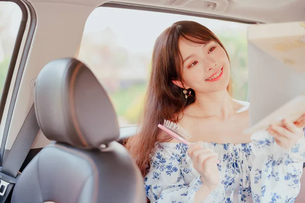 Fashionable Asian girls make up in the car