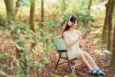 Kızlar parkta tablet bilgisayar kullanırlar