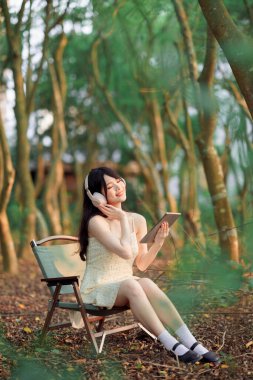 Kızlar parkta tablet bilgisayar kullanırlar