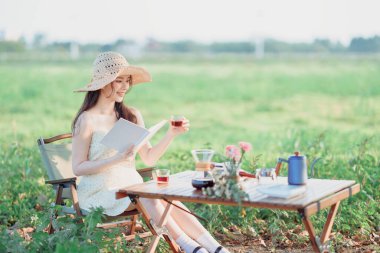 Kız okuyor ve kahvenin tadını çıkarıyor.