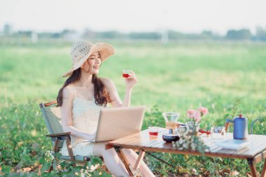 Asyalı kızlar kamp sırasında dizüstü bilgisayar kullanır.