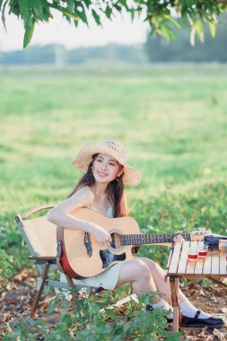 Kampta gitar çalan Asyalı kız.