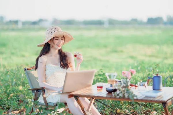 Asian girls use laptops during camping