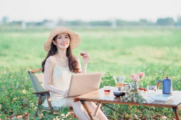 Asian girls use laptops during camping