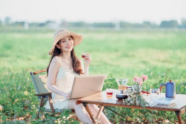 Asian girls use laptops during camping