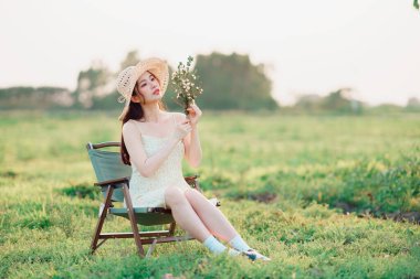 Moda kızı buketi çimlerin üzerinde tutuyor.