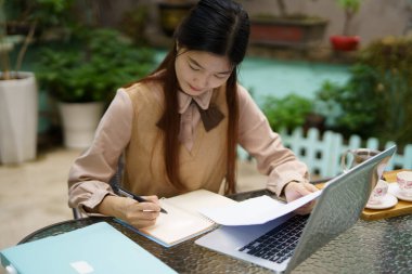 Asyalı kızlar avluda çalışıyor.