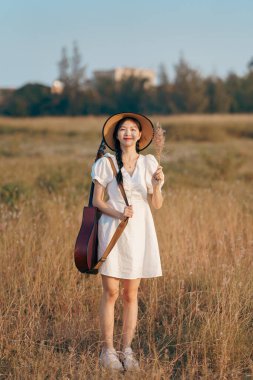 Parkta gitar çalan mutlu kız.