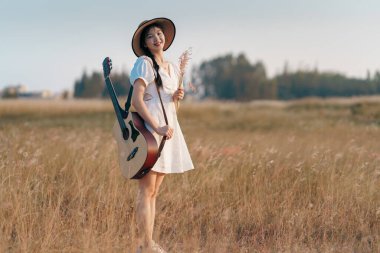 Parkta gitar çalan mutlu kız.