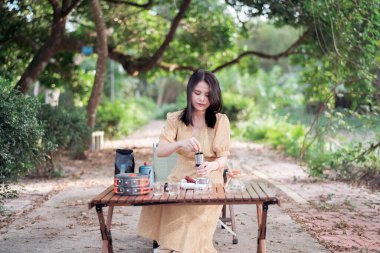 Kız bahçede kahve yapıyor.