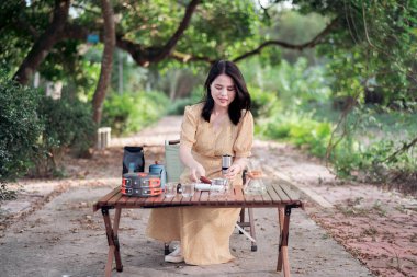 Kız bahçede kahve yapıyor.