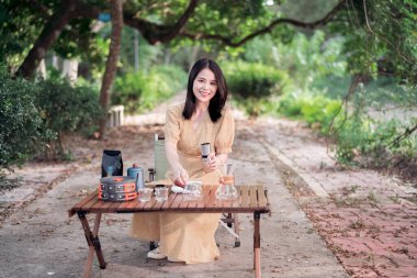 Kız bahçede kahve yapıyor.