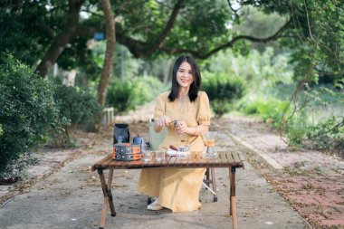 Kız bahçede kahve yapıyor.