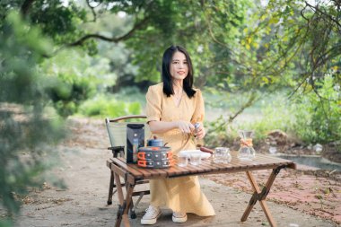 Kız bahçede kahve yapıyor.