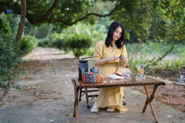 Kız bahçede kahve yapıyor.