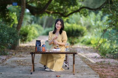 Kız bahçede kahve yapıyor.