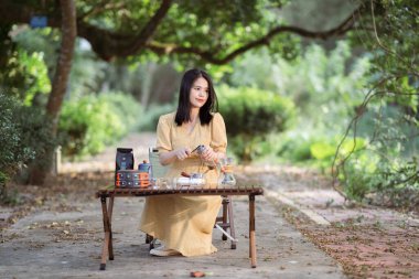 Kız bahçede kahve yapıyor.