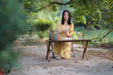 Kız bahçede kahve yapıyor.