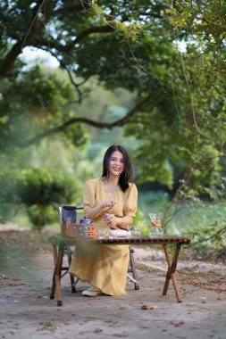 Kız bahçede kahve yapıyor.