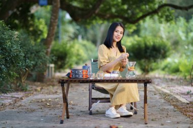 Kız bahçede kahve yapıyor.