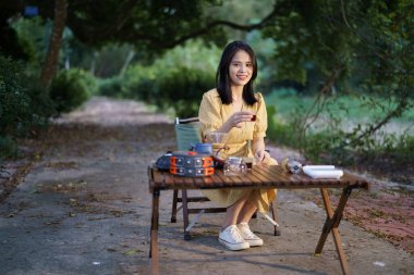 Kız bahçede kahve yapıyor.