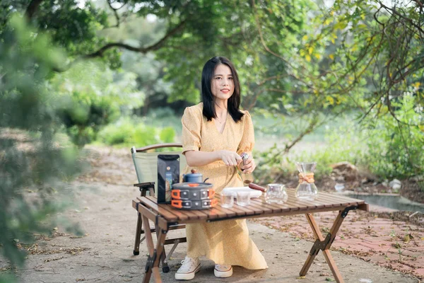 Kız bahçede kahve yapıyor.