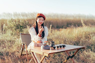 Asyalı kızlar kampta çay yapar.