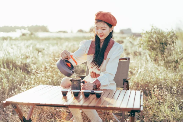 Asian girls make tea at camp