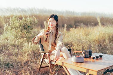 Asyalı kızlar banliyöde çay yapar.