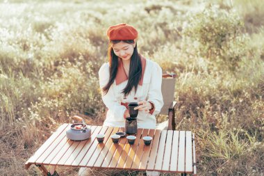 Asyalı kızlar banliyöde çay yapar.