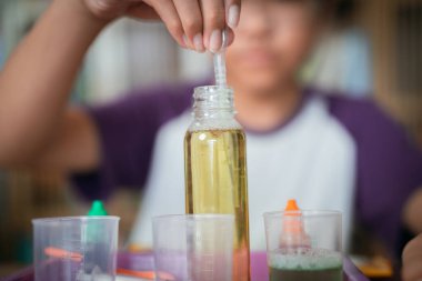 Küçük çocuk laboratuarda kimyasal deney yapıyor.