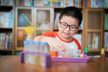 Küçük çocuk laboratuarda kimyasal deney yapıyor.